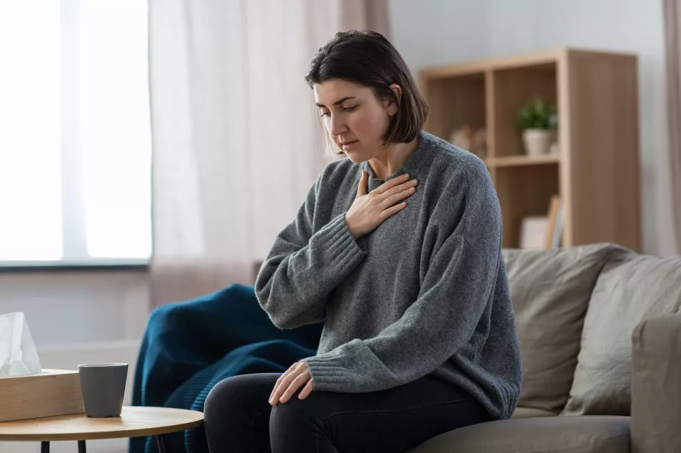 Young woman is nervous while sitting on sofa at home 